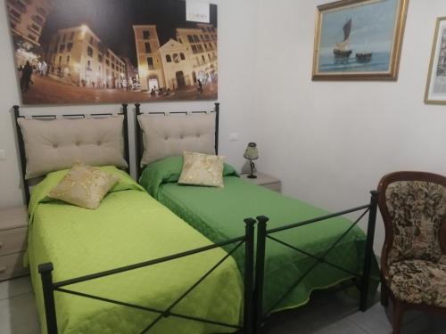 1 Schlafzimmer mit 2 Betten und grüner Bettwäsche in der Unterkunft Tuttoincentro in Salerno