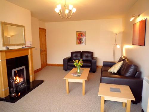 a living room with a couch and a fireplace at Innisfallen Holiday Homes by Trident Holiday Homes in Killarney