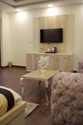 a living room with a coffee table and a tv at Maps Inn in Ghaziabad