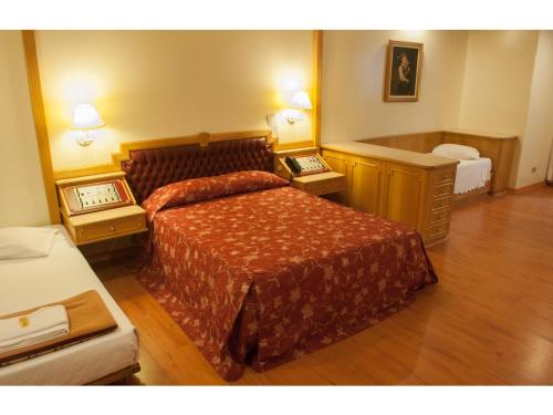 a hotel room with a bed and two night stands at King Hotel in Sao Paulo