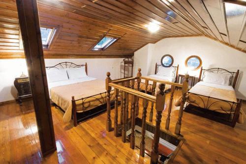 a bedroom with two beds and a wooden ceiling at Villa Kastanodasos in Emporio
