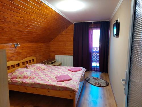 a small bedroom with a bed and a table at Casa Neagu in Covasna