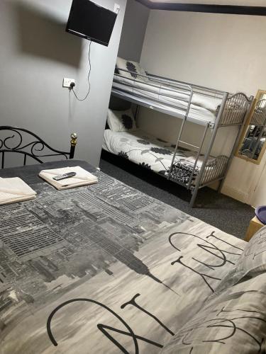 a room with two bunk beds and a bed with writing on it at The Woodfield Hotel , Indoor Heated swimming pool, Spacious lounge and Bar in Blackpool