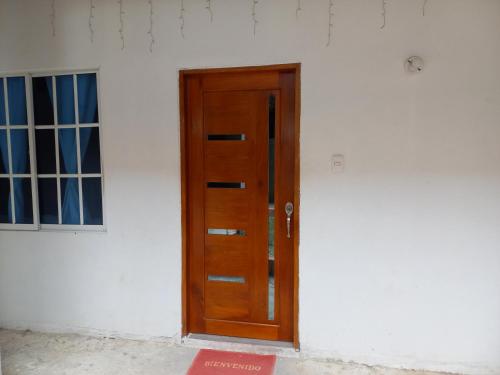 a wooden door on the side of a white wall at Casa Hotel Alborada in San Antero
