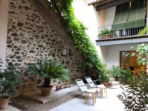 eine Terrasse mit Stühlen und Pflanzen sowie ein Gebäude in der Unterkunft La villa Marseillanaise in Marseillan