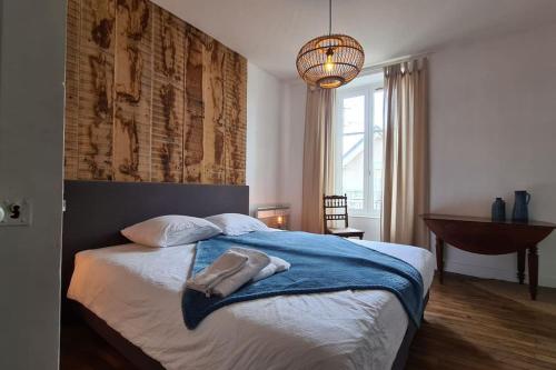 a bedroom with a bed with a blue blanket on it at Charming and comfortable house in Treignac