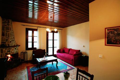 a living room with a red couch and a table at Villa Kastanodasos in Emporio