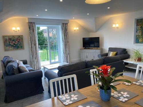 a living room with couches and a table and a television at Longwood Forest Apartment in Bartley