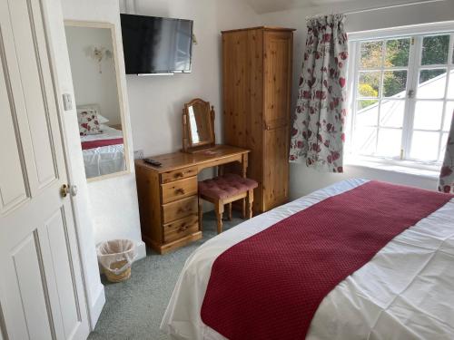 a bedroom with a bed and a dresser and a television at Longwood Forest Apartment in Bartley