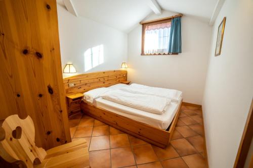 a small bedroom with a bed and a window at Residence Derby Club in Folgaria