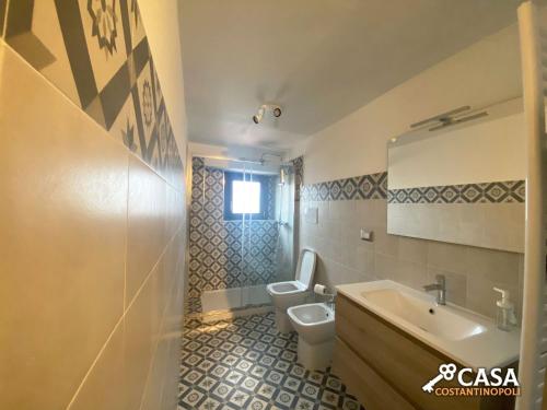 een badkamer met een wit toilet en een wastafel bij Casa Costantinopoli in Padula