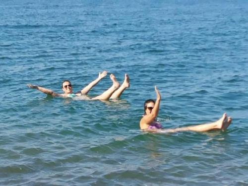 two people laying on their backs in the water at Aitch Boutique Hotel - an LIH Hotel in Madaba