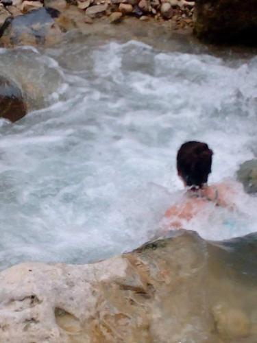 a person in a hot spring in a river at Aitch Boutique Hotel - an LIH Hotel in Madaba