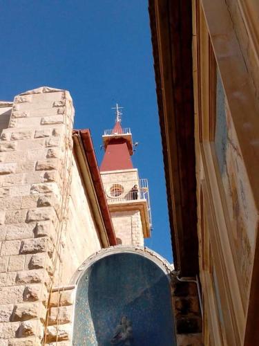 a building with a clock tower with a window at Aitch Boutique Hotel - an LIH Hotel in Madaba