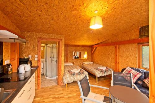 uma cozinha e sala de estar num chalé de madeira em Caledonian Glamping em Cannich