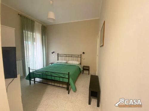 een slaapkamer met een bed met een groene deken bij Casa Costantinopoli in Padula
