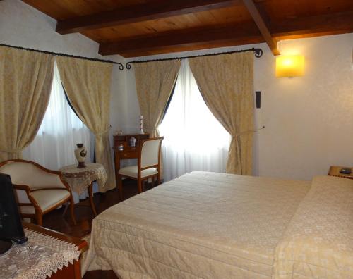 Schlafzimmer mit einem Bett, einem Tisch und Stühlen in der Unterkunft Hotel San Giuseppe in Gerace