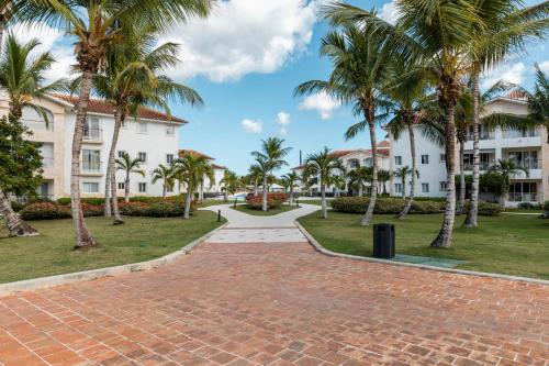 a brick walkway in front of a building with palm trees at Hotel Palmera Bayahibe in Bayahibe