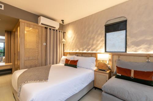a bedroom with a large white bed and a window at Landmark Hotel in Medellín