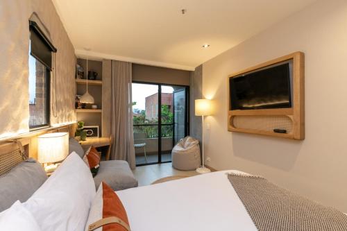 a bedroom with a bed and a flat screen tv at Landmark Hotel in Medellín