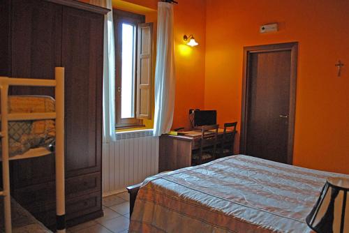 a bedroom with a bed and a desk and a window at Agriturismo Aia Antica in Padula