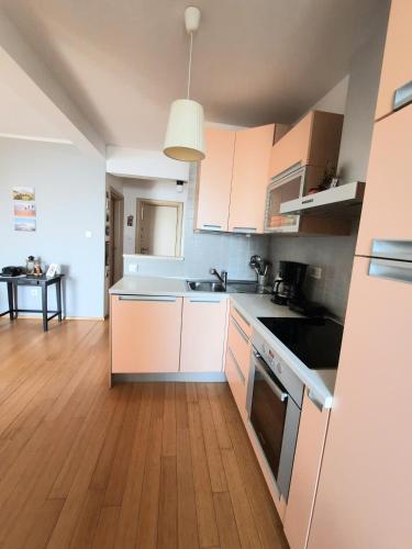 a kitchen with white cabinets and a wooden floor at MORABEZA Opatija in Opatija