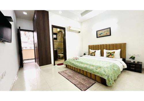 Un dormitorio con una cama grande y un televisor. en BluO 2BHK - Greater Kailash Lift Balcony Parking, en Nueva Delhi