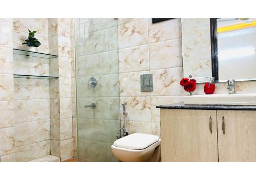 a bathroom with a toilet and a sink at BluO 2BHK - M Block Balcony, Parking , Lift in New Delhi
