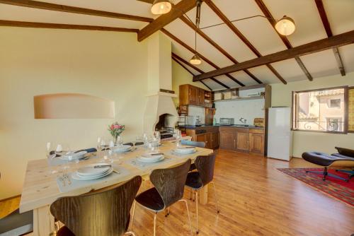 une salle à manger avec une table et une cuisine dans l'établissement Ancienne Mairie Vieux Village Roquebrune 3 bedroom apartment, à Roquebrune-Cap-Martin
