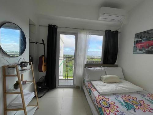 ein Schlafzimmer mit einem Bett und einem großen Fenster in der Unterkunft Cool Suites at Wind Residences Tagaytay Staycation- IM HANA 1 in Tagaytay