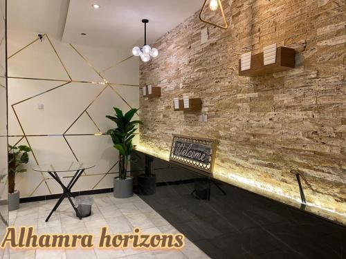 a room with a stone wall and a bench at Alhamra Horizons in Al Ḩamrāʼ