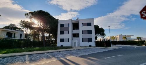 a white building on the side of a street at The Apartments in VALAMAR in Hamallë