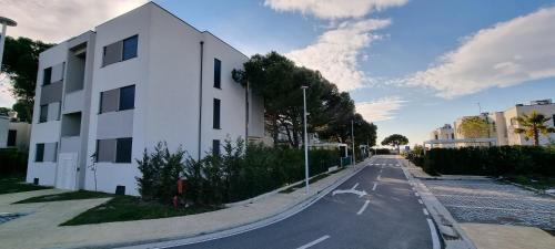 a white building on the side of a street at The Apartments in VALAMAR in Hamallë