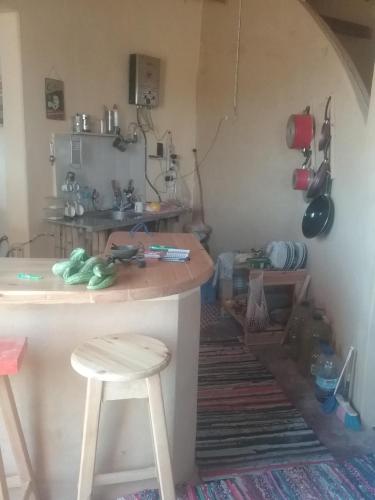a kitchen with a counter and two stools in a room at Hidden place in Siwa