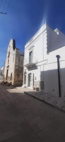 - un bâtiment blanc avec un balcon sur le côté dans l'établissement B&B La Maddalena, à Sammichele di Bari
