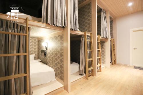 a room with four bunk beds in it at Anho Chew Hotel in Luodong