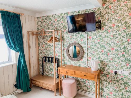 a bathroom with a vanity and a tv on the wall at The Townhouse 101 in Sandown