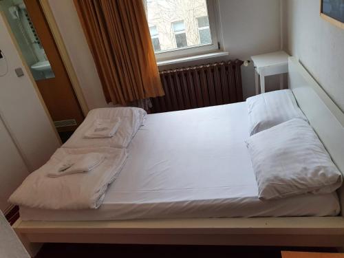 a bed with two pillows on it in a room at Märkischer Hof Hotel in Berlin
