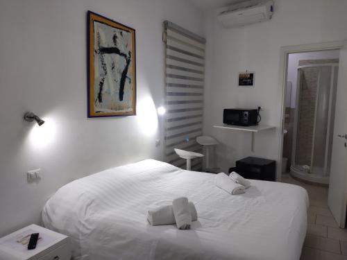 um quarto com uma cama branca e toalhas em Guest House San Pietro em Roma