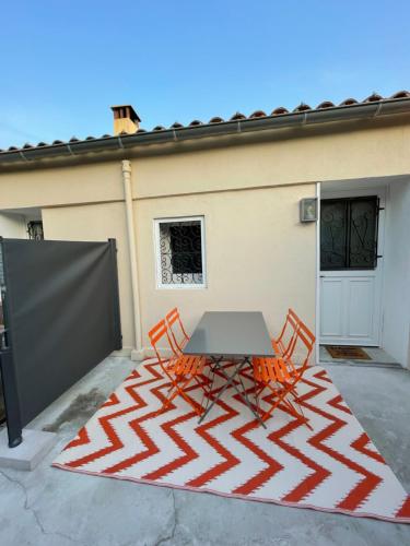 Una mesa y dos sillas en un patio. en Le petit cassis, en Cassis