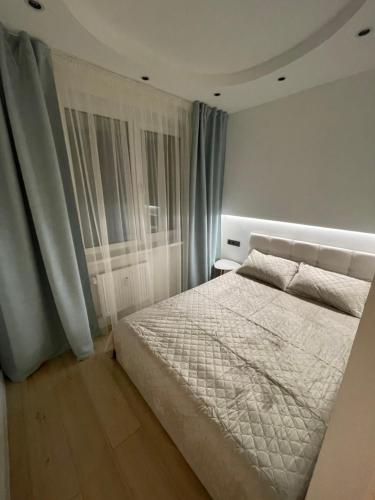 - une chambre avec un lit blanc et une fenêtre dans l'établissement Livinga Lovely 1-bedroom apartment, à Mažeikiai