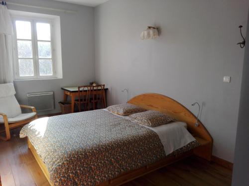 a bedroom with a bed and a chair and a window at Mas Bohème in Espeluche