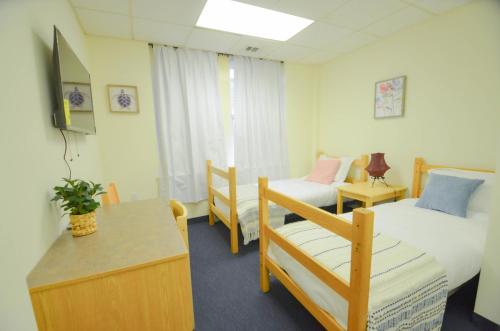 a room with two beds and a table and a chair at Michie House in College Hill in Providence