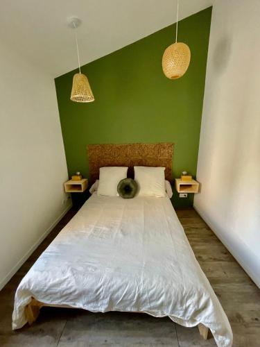 une chambre avec un grand lit avec un mur végétal dans l'établissement Le petit cassis, à Cassis