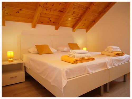 a bedroom with a large bed with yellow towels on it at House Natalija in Podgreben