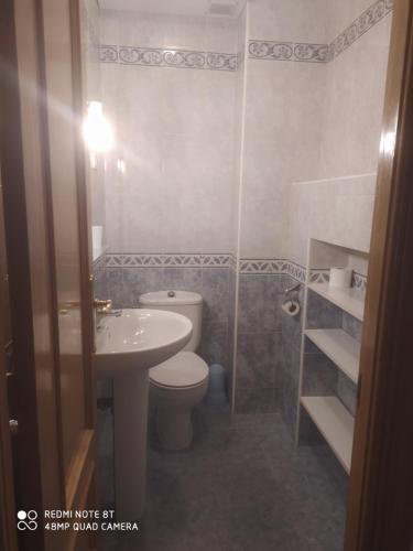a bathroom with a toilet and a sink at Vivienda céntrica en Las Navas in Las Navas del Marqués