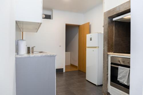 una cucina con frigorifero bianco e piano cottura di Entrecampos - Two bedroom apartment with Terrace a Lisbona
