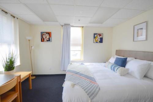 a bedroom with a bed and a desk and a window at Michie House in College Hill in Providence