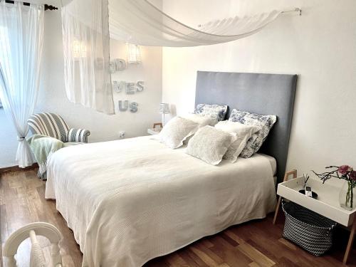 a bedroom with a large bed with white sheets and pillows at Casa das Cores in Sesimbra