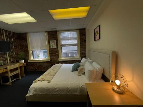 a bedroom with a bed and a desk and two windows at Michie House in College Hill in Providence